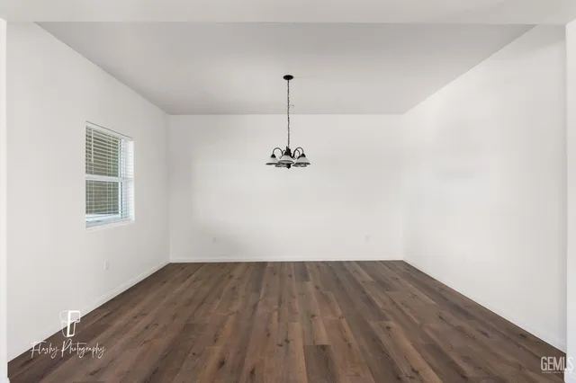 a view of a room with wooden floor and a ceiling fan