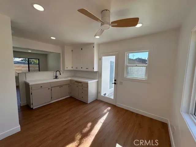 a kitchen with a sink cabinets and wooden floor