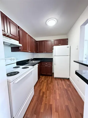 a kitchen with wooden cabinets and white appliances