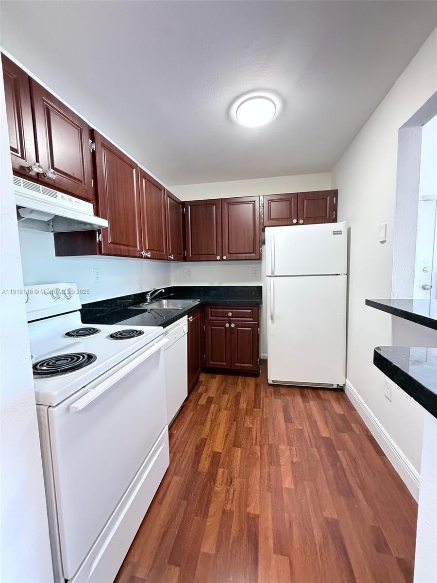 a kitchen with wooden cabinets and white appliances