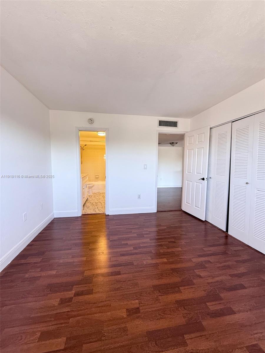 7100 Northwest 179th Street, Unit 305 Hialeah, FL 33015 - Photo 3 of 7 a view of empty room with wooden floor and fan
