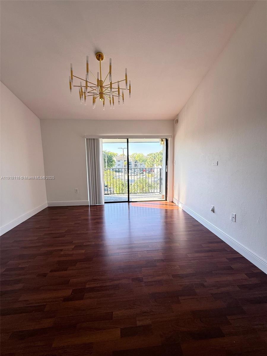 7100 Northwest 179th Street, Unit 305 Hialeah, FL 33015 - Photo 5 of 7 a view of a room with wooden floor and window