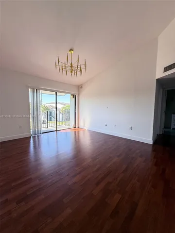 an empty room with wooden floor and window