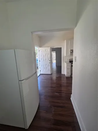 a view of hallway with wooden floor and electronic appliances