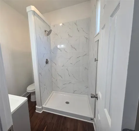a bathroom with a tub shower and toilet