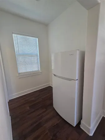 a view of kitchen with refrigerator and wooden floor