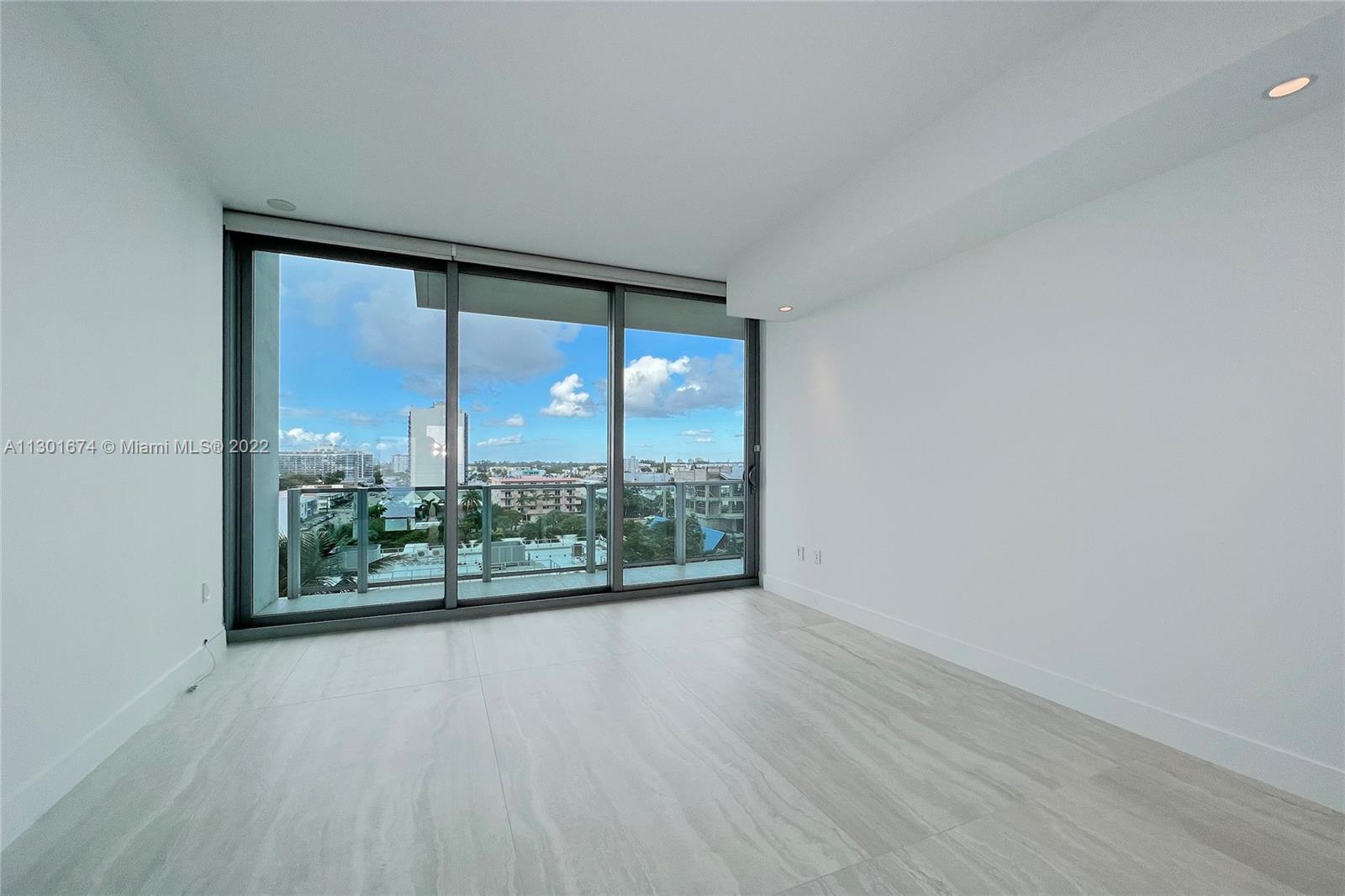North Beach Miami Beach, FL 33141 - Photo 16 of 23 an empty room with wooden floor and windows