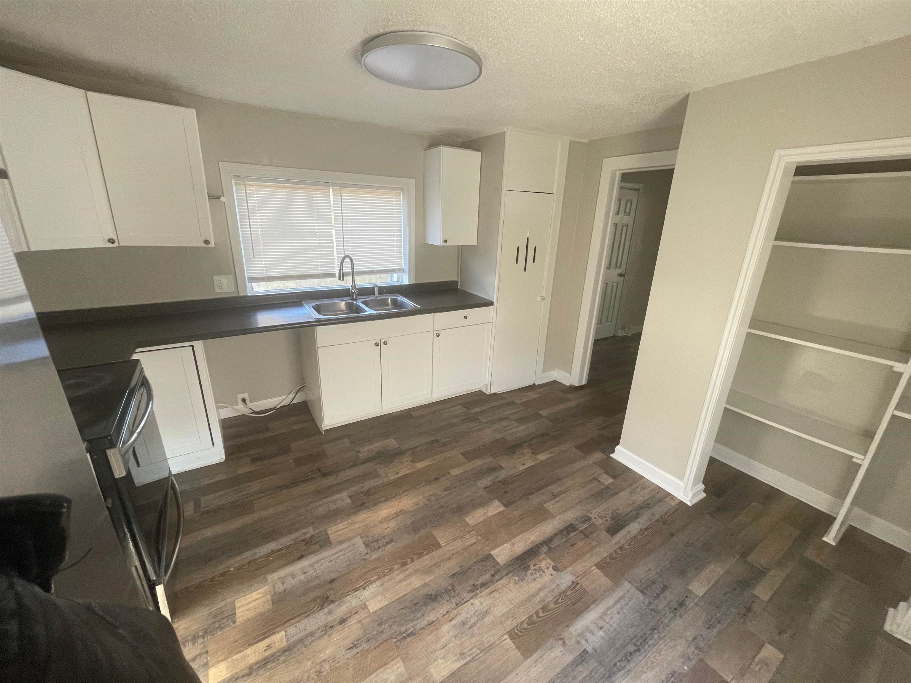3466 Carrington Road Memphis, TN 38111 - Photo 14 of 14 a kitchen with granite countertop white cabinets and wooden floor