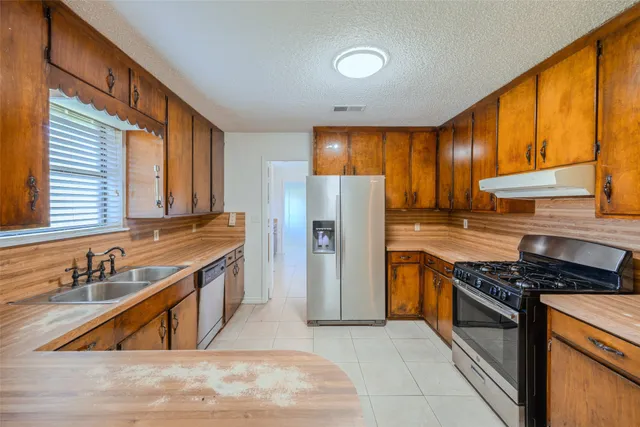 a kitchen with stainless steel appliances granite countertop a sink stove and cabinets