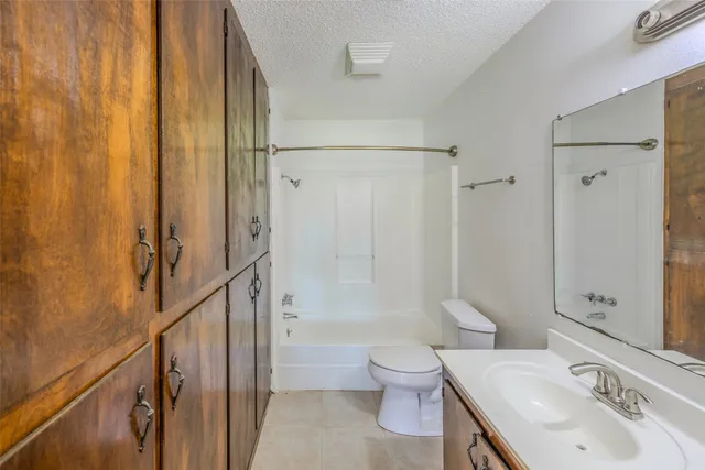 an empty room with wooden floor ceiling fan and windows
