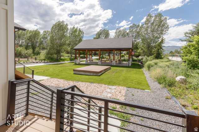 1188 South Old Trappers Loop Road Huntsville, UT 84317 - Photo 72 of 92 Outdoor gathering area featuring a covered pavilion with stone pillars, a wooden stage, and a manicured lawn
