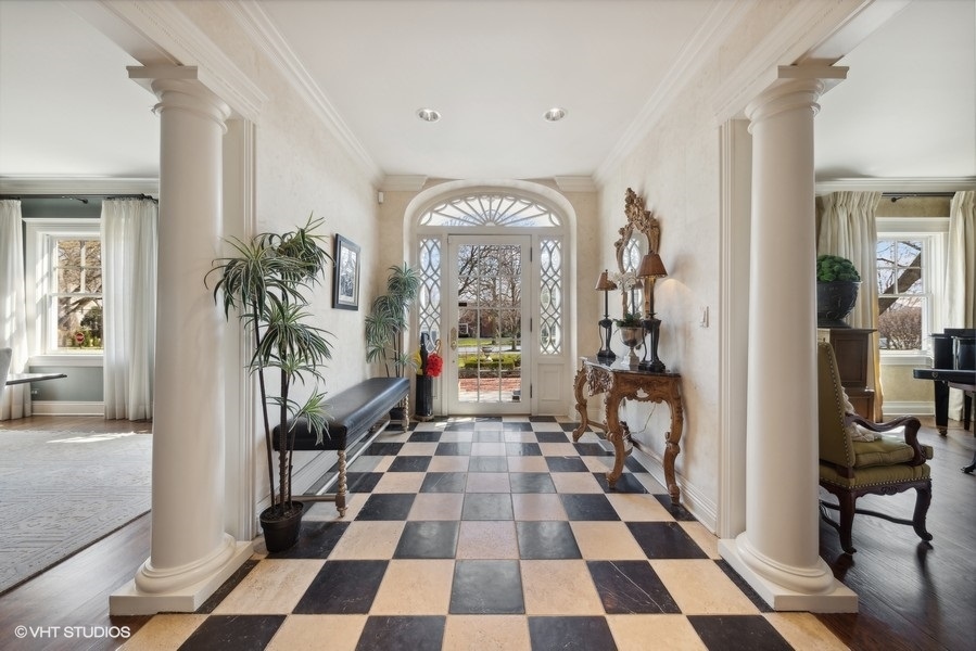 710 South County Line Road Hinsdale, IL 60521 - Photo 11 of 63 a hallway with a black white checkered floor and a large mirror on a table