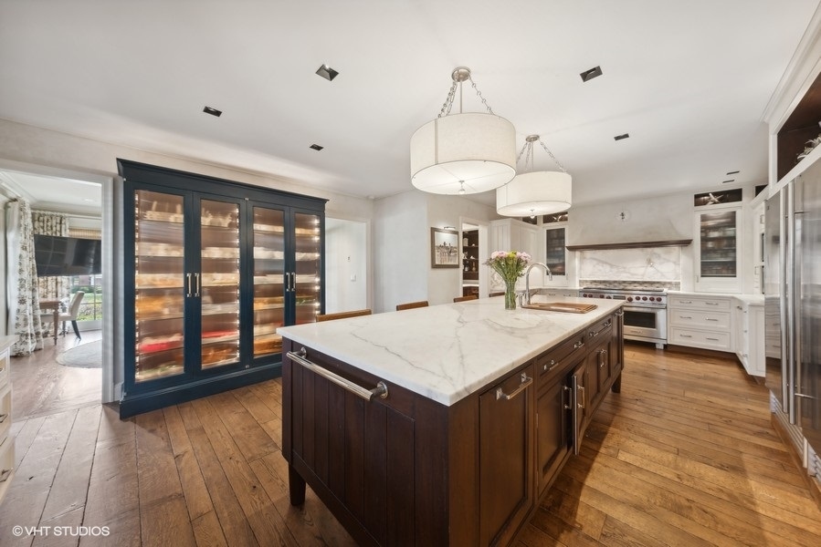 710 South County Line Road Hinsdale, IL 60521 - Photo 14 of 63 a large kitchen with kitchen island a sink a stove and a wooden floors
