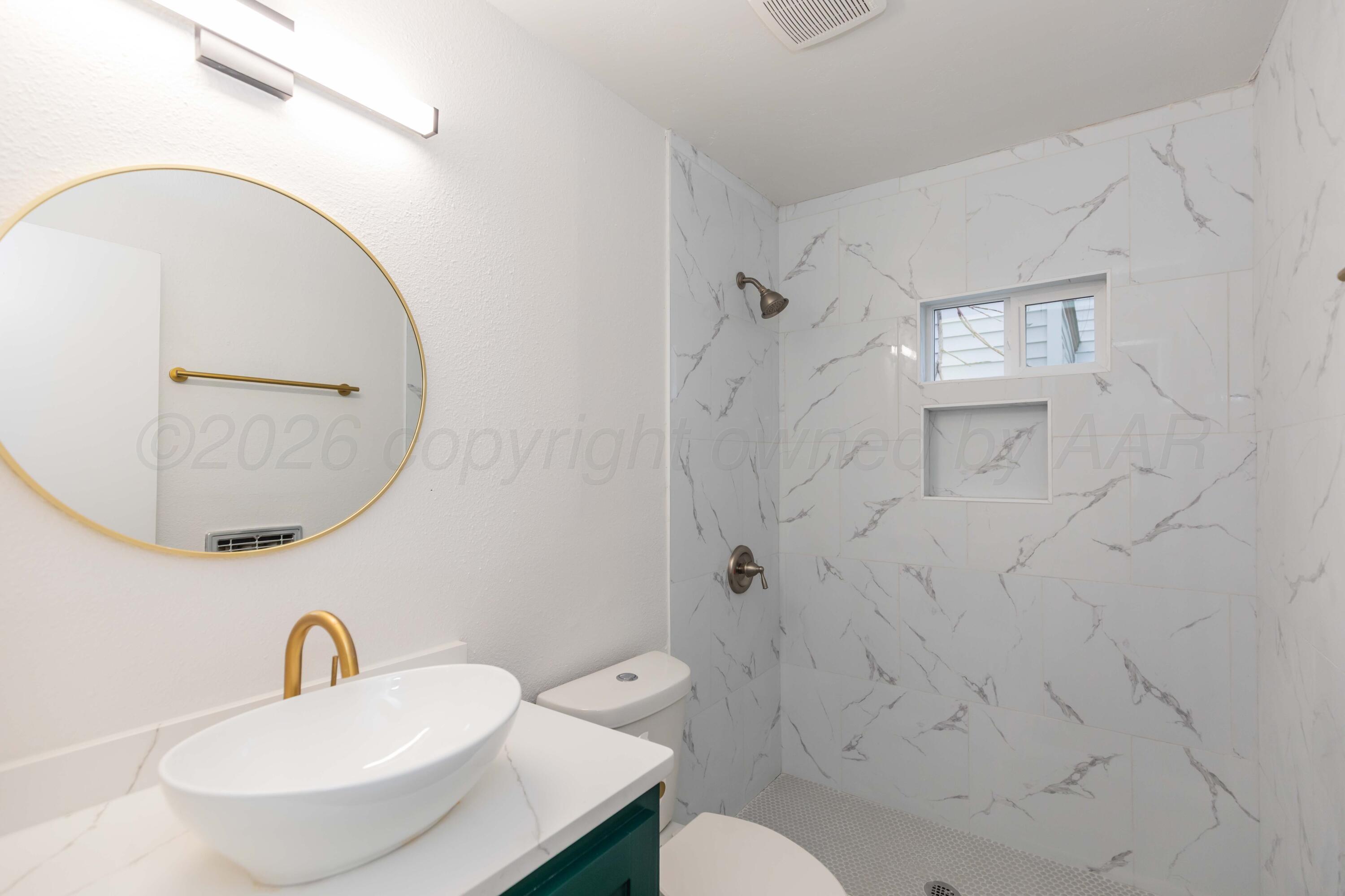 205 South Forest Street Amarillo, TX 79106 - Photo 3 of 29 a bathroom with a sink a mirror a toilet and a mirror