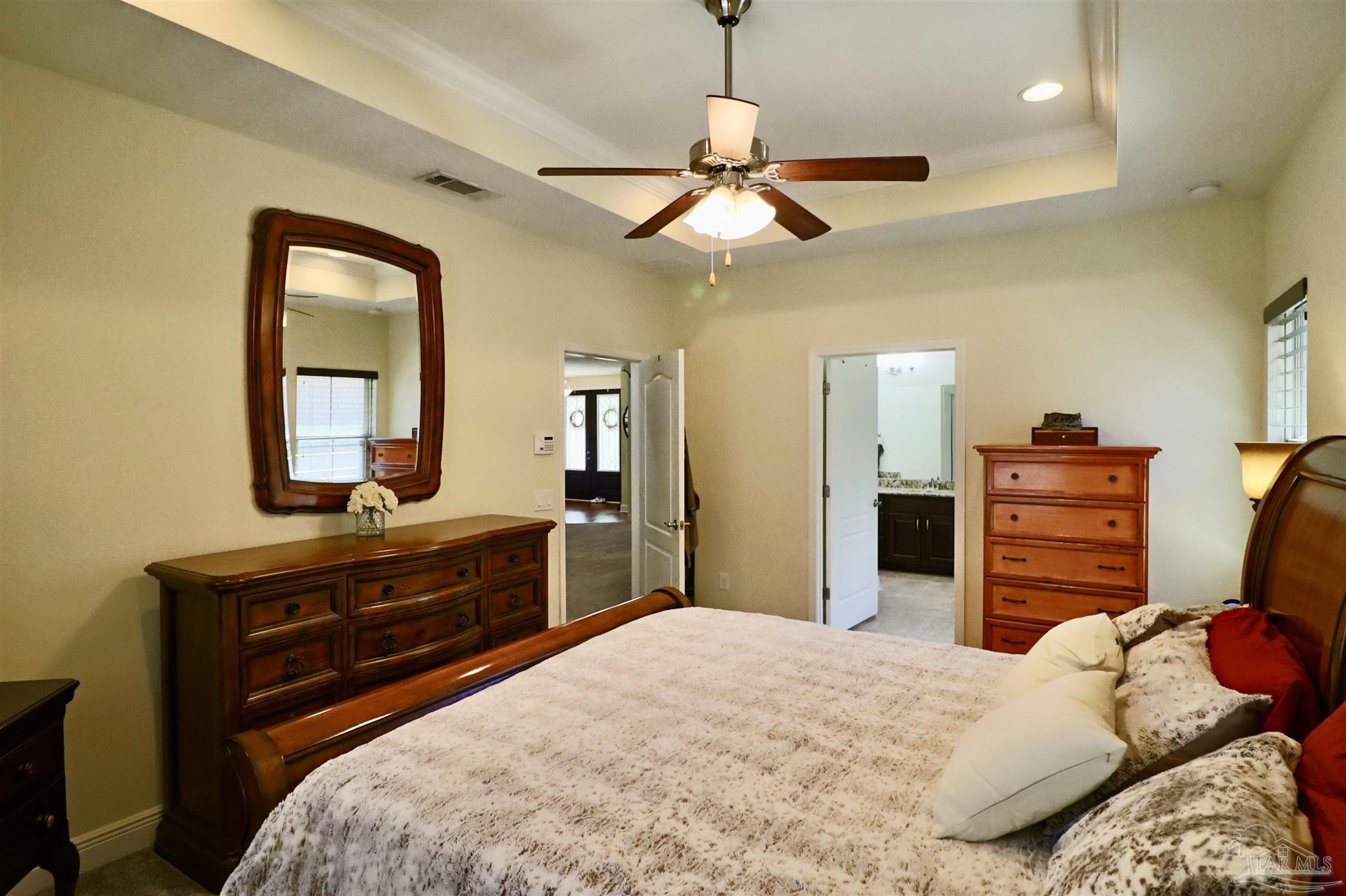 3934 Fielding Court Pace, FL 32571 - Photo 23 of 49 a bedroom with a bed and dresser with mirror