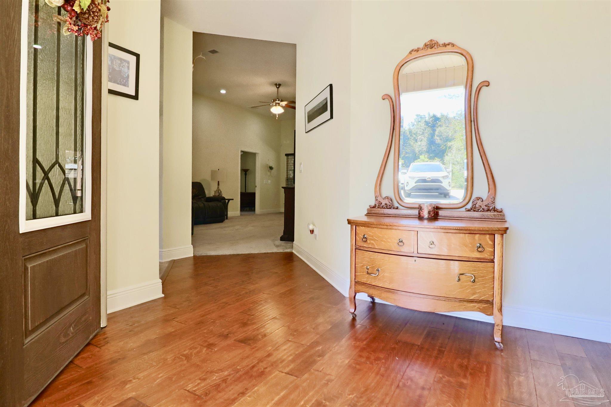 3934 Fielding Court Pace, FL 32571 - Photo 6 of 49 a view of a hallway with wooden floor and a living room