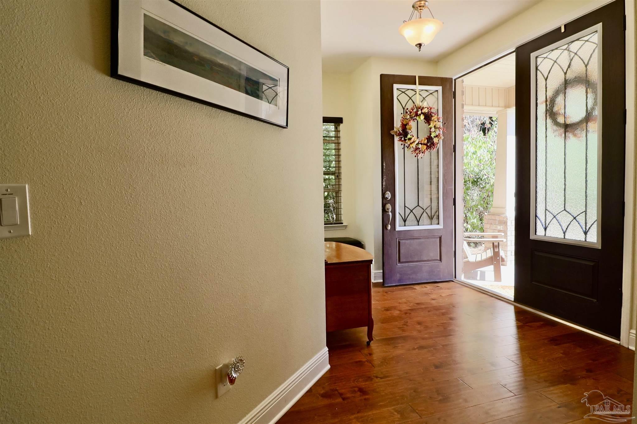 3934 Fielding Court Pace, FL 32571 - Photo 8 of 49 a view of a hallway with wooden floor and door