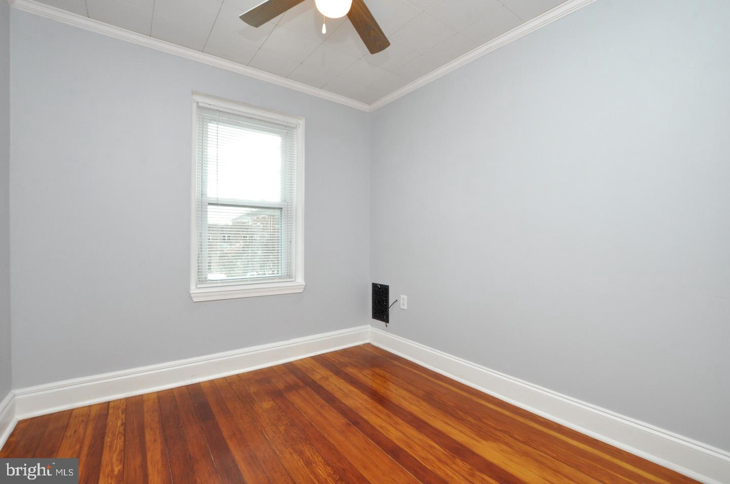 3069 South Chesapeake Road Camden, NJ 08104 - Photo 11 of 30 an empty room with wooden floor chandelier fan and windows