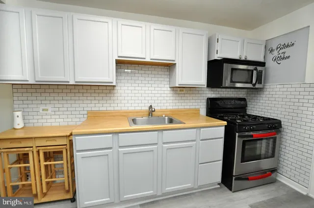 a kitchen with a sink a refrigerator and cabinets