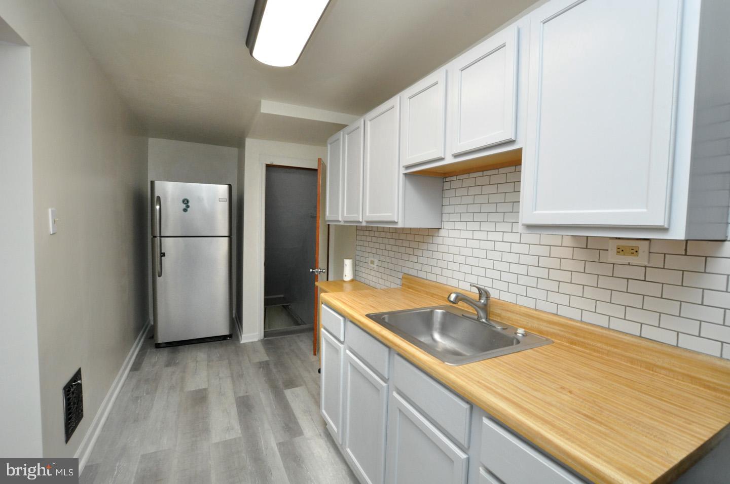 3069 South Chesapeake Road Camden, NJ 08104 - Photo 21 of 30 a kitchen with a sink a refrigerator and cabinets
