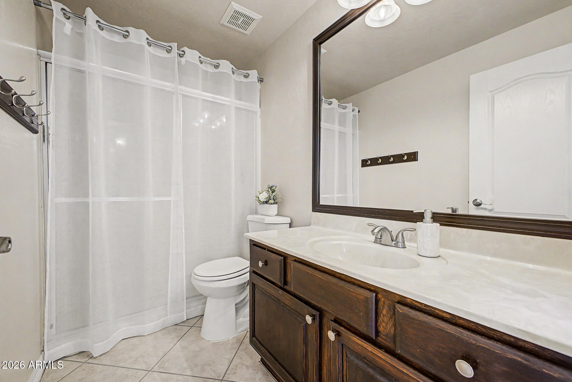 1124 North Robin Lane Mesa, AZ 85213 - Photo 22 of 87 a bathroom with a sink a toilet a mirror and shower