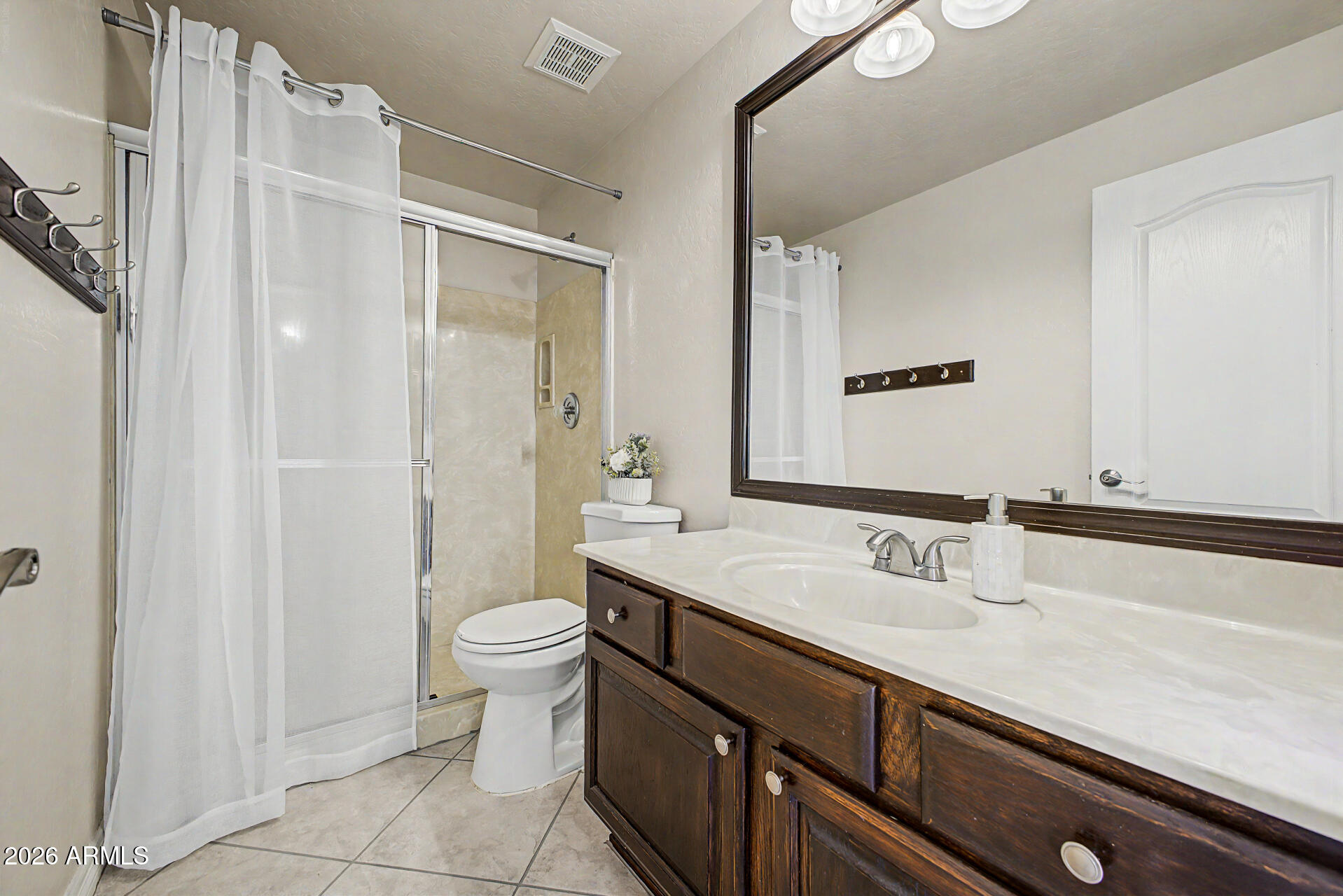 1124 North Robin Lane Mesa, AZ 85213 - Photo 71 of 87 a bathroom with a sink a toilet a mirror and shower