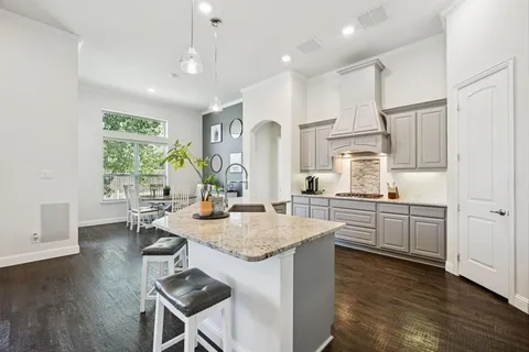 a kitchen with granite countertop kitchen island white cabinets and stainless steel appliances