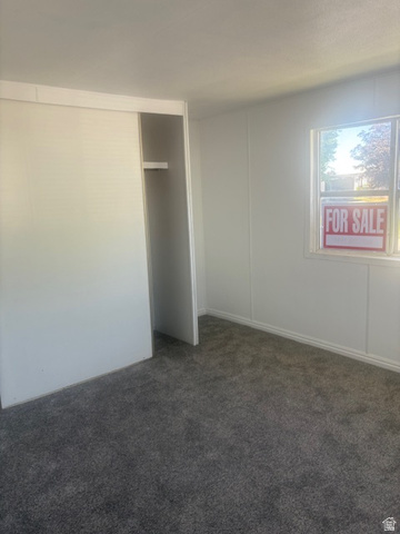 1111 North 2000 West, Unit 293 Farr West, UT 84404 - Photo 5 of 13 Carpeted room featuring a white sliding closet door and a single window