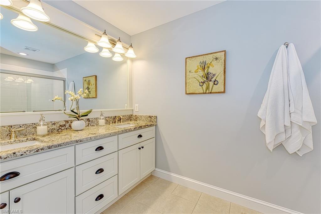 988 Hampton Circle Naples, FL 34105 - Photo 11 of 20 a bathroom with a double vanity sink and a mirror