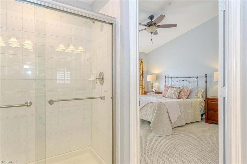 988 Hampton Circle Naples, FL 34105 - Photo 12 of 20 a view of a bedroom with a bed and a chandelier fan
