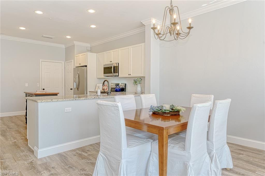 988 Hampton Circle Naples, FL 34105 - Photo 3 of 20 a kitchen with stainless steel appliances granite countertop a dining table chairs and a refrigerator