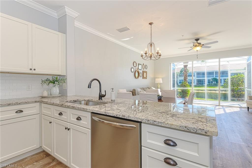 988 Hampton Circle Naples, FL 34105 - Photo 8 of 20 a kitchen with granite countertop a sink and white cabinets