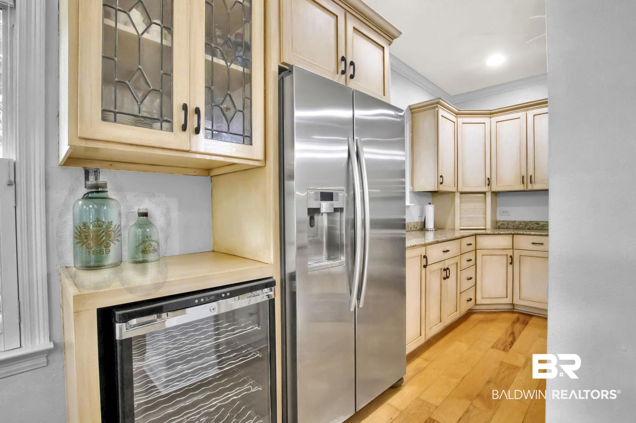 9002 Parliament Circle Daphne, AL 36526 - Photo 26 of 73 Kitchen with stainless steel refrigerator with ice dispenser, beverage cooler, light hardwood floors, ornamental molding, and light brown cabinets