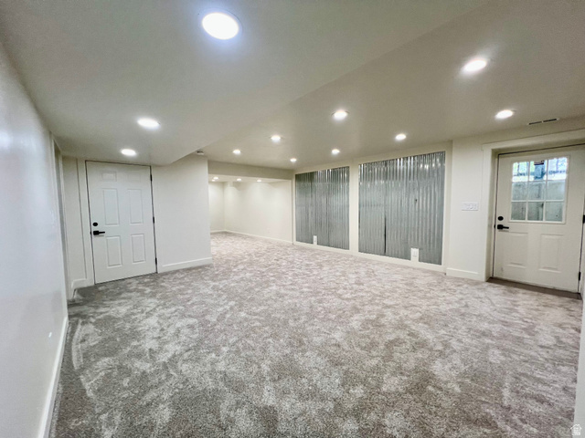 812 East Bates Cyn Road Tooele, UT 84074 - Photo 78 of 144 Spacious finished room featuring recessed lighting, light-toned textured carpet, white panel doors, and corrugated metal wall accents