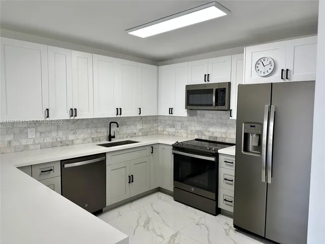 a kitchen with stainless steel appliances granite countertop a stove top oven and sink