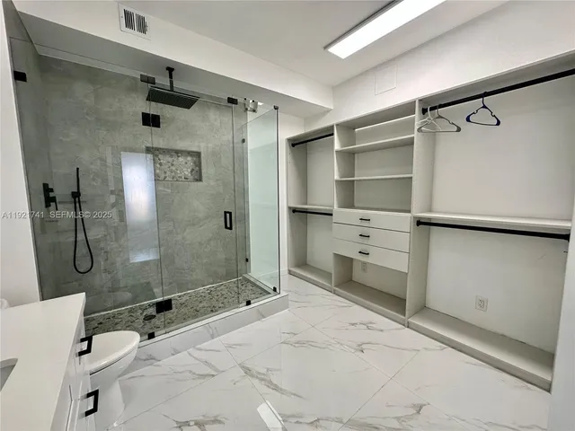 a bathroom with a double vanity sink toilet and shower