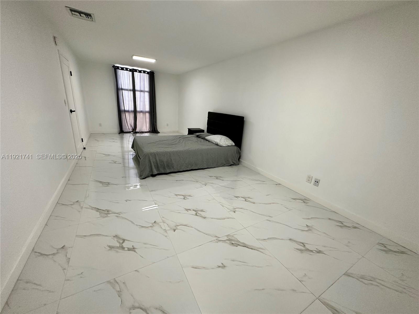 13499 Biscayne Boulevard, Unit PH1709 North Miami, FL 33181 - Photo 8 of 11 a bedroom with a bed and window