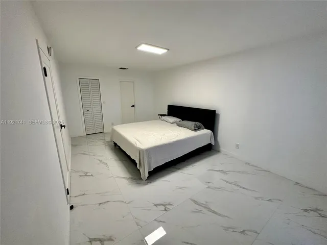 a view of a bedroom with a bed and a window