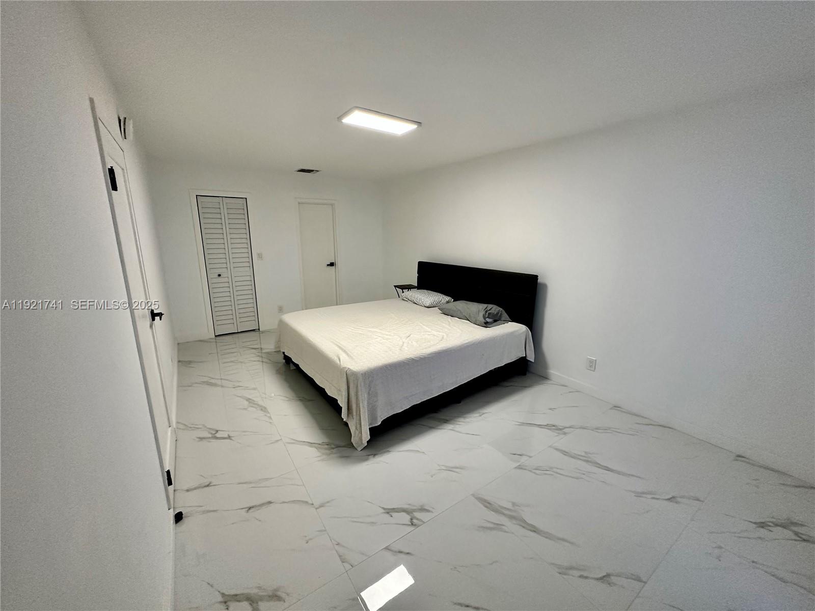 13499 Biscayne Boulevard, Unit PH1709 North Miami, FL 33181 - Photo 9 of 11 a view of a bedroom with a bed and a window