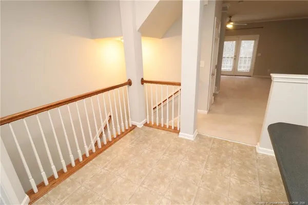 a view of a hallway with wooden floor and windows