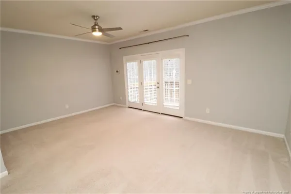 an empty room with windows and fan