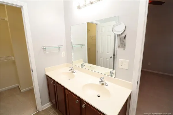 a spacious bathroom with a double vanity sink toilet and shower