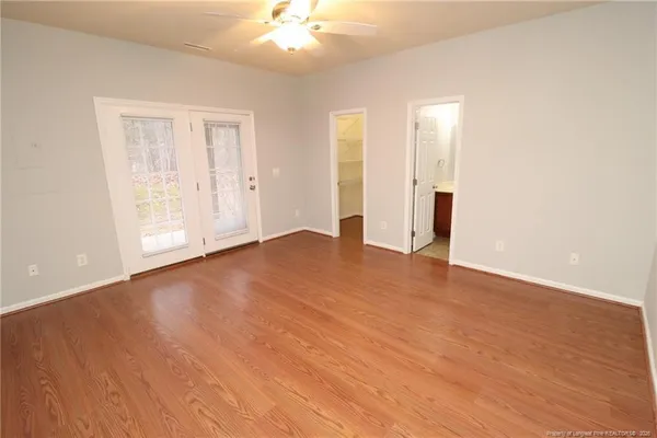an empty room with wooden floor and windows
