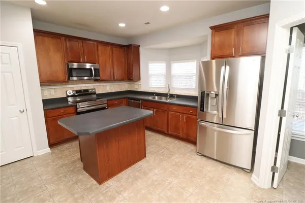 a kitchen with stainless steel appliances granite countertop a refrigerator stove microwave and sink