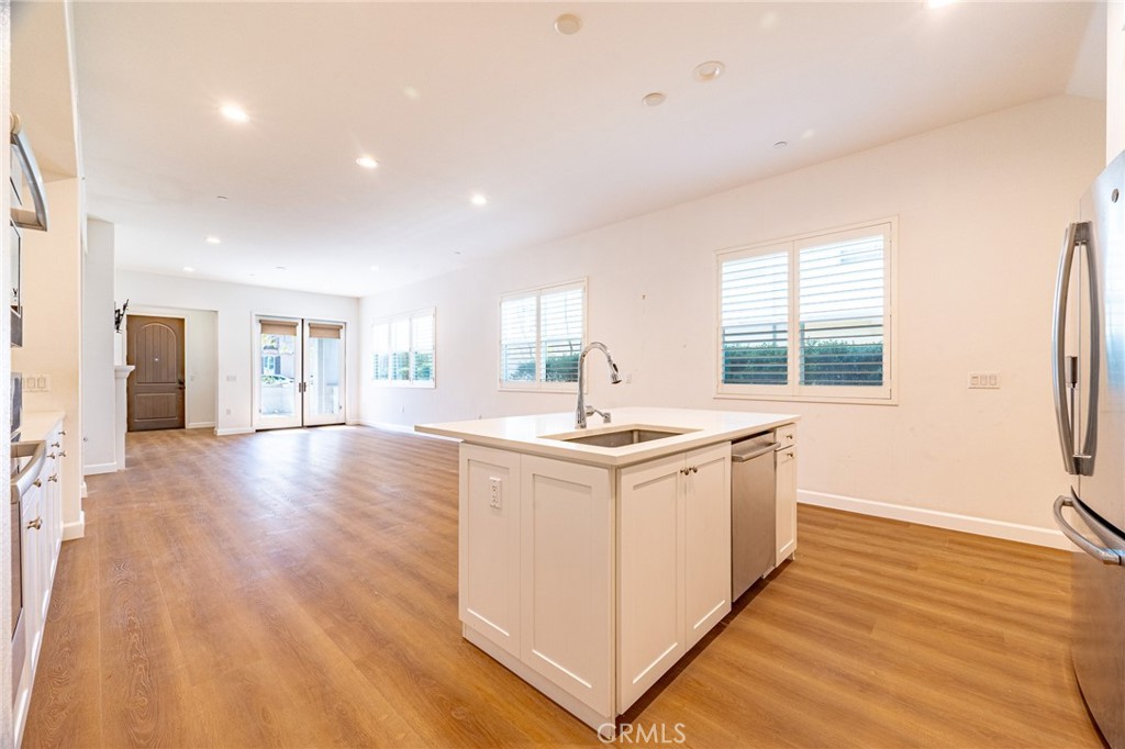 172 Follyhatch Irvine, CA 92618 - Photo 13 of 39 a large white kitchen with wooden floor and a sink