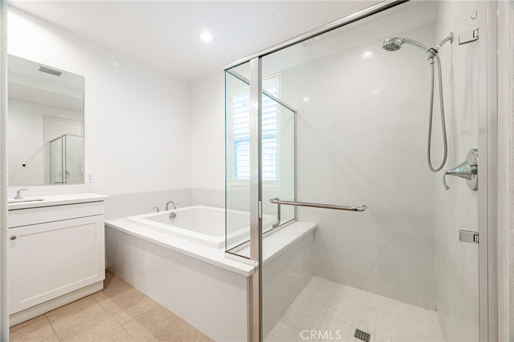 172 Follyhatch Irvine, CA 92618 - Photo 25 of 39 a bathroom with a tub sink a mirror a shower and vanity