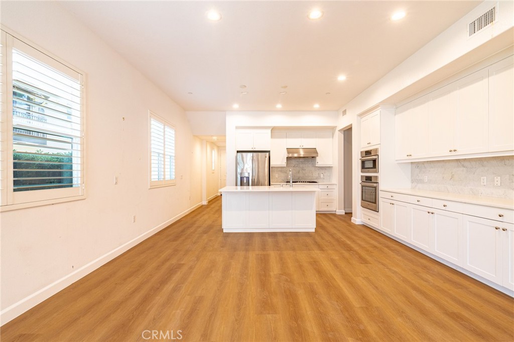 172 Follyhatch Irvine, CA 92618 - Photo 6 of 39 a living room with stainless steel appliances kitchen island wooden floor and large windows