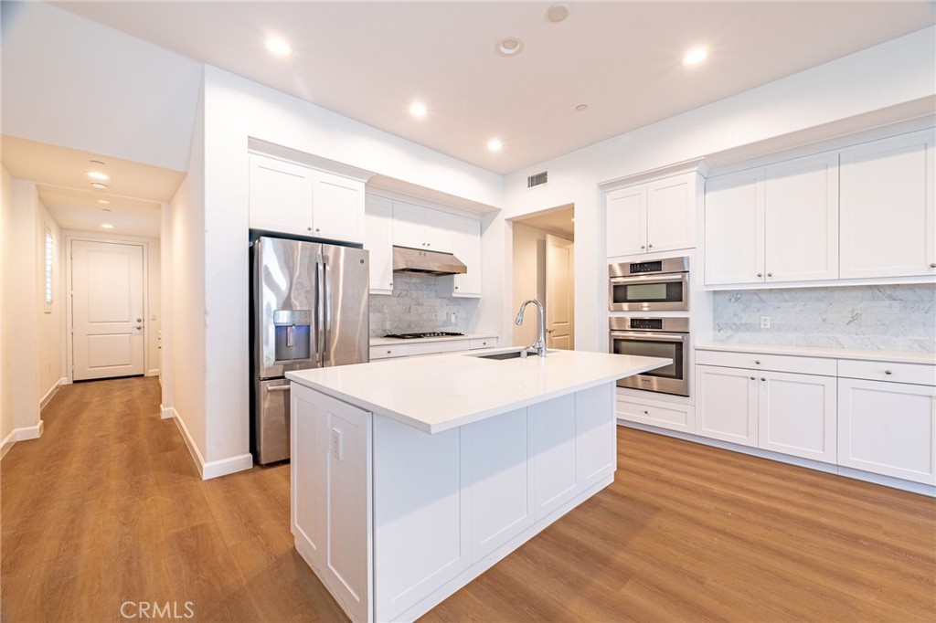 172 Follyhatch Irvine, CA 92618 - Photo 10 of 39 a kitchen with stainless steel appliances a white stove top oven cabinets a refrigerator and a sink