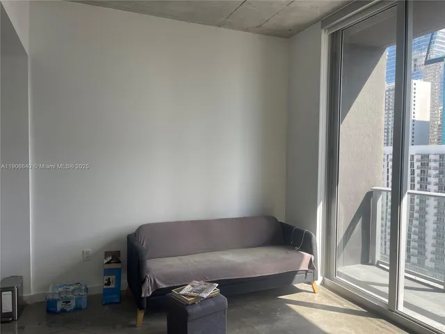 a living room with furniture and a floor to ceiling window