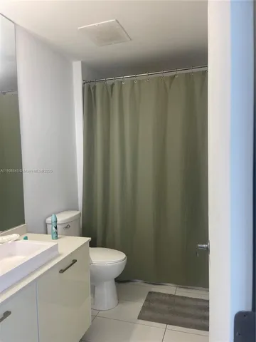 a bathroom with a sink a toilet and shower curtain
